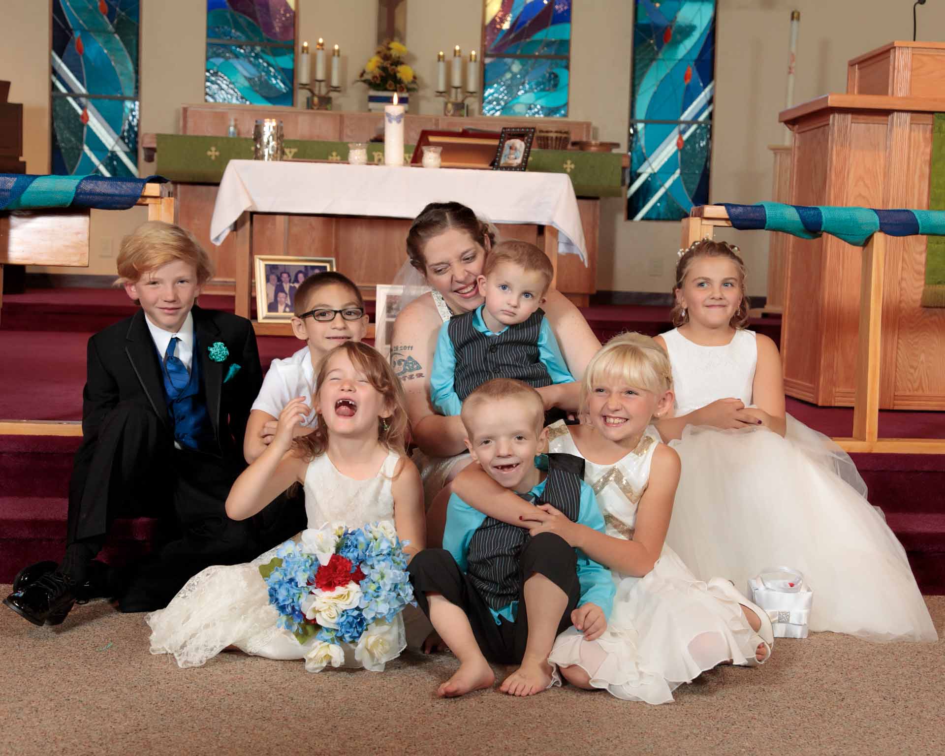Young bride surrounded with children on her wedding day