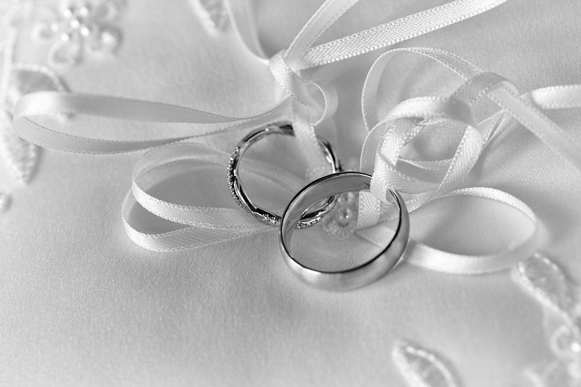 Wedding rings on a white satin pillow
