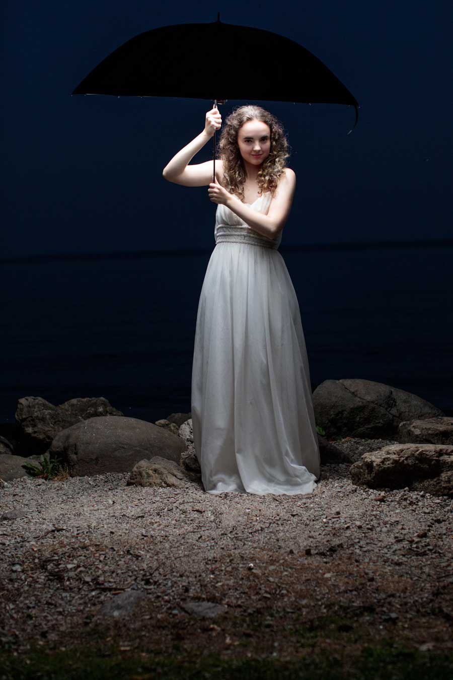 Young model in white dress at night

