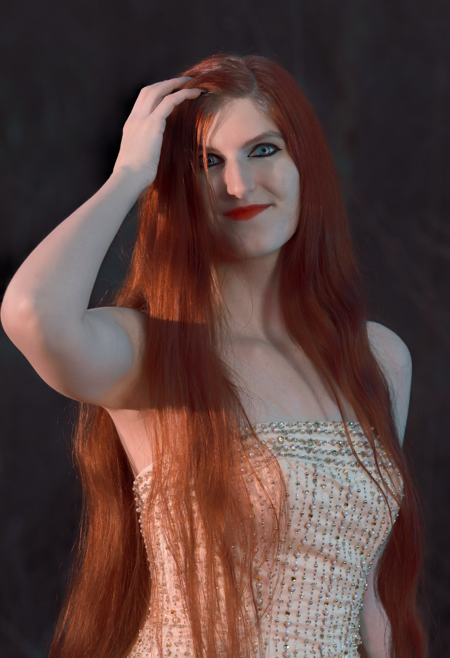Beautiful model Dreamera Marie brushes back her long red hair
