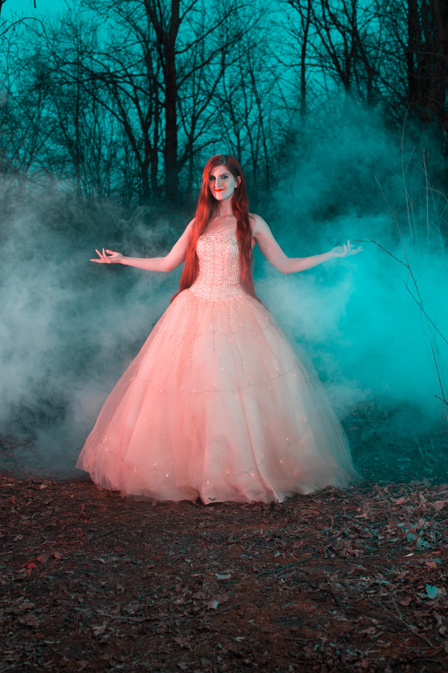 Model Dreamera Marie poses in the woods with a smoky background
