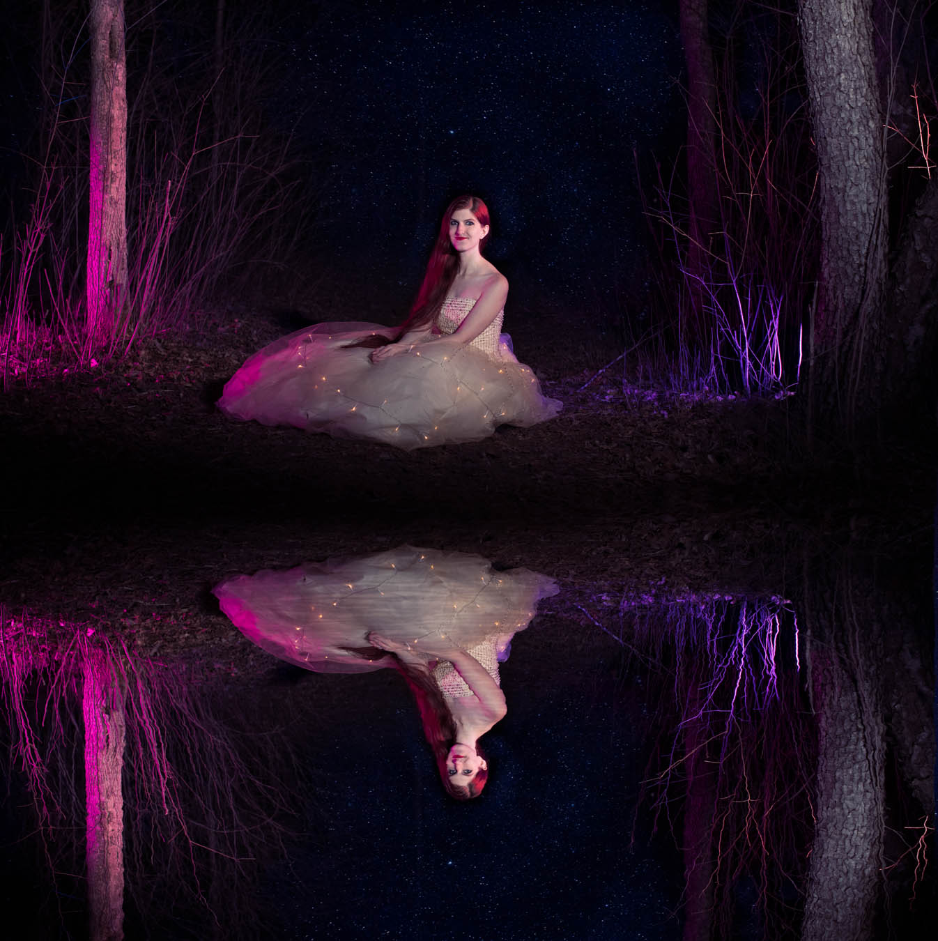 Beautiful model Dreamera Marie poses by a lake at night with a reflection from the water

