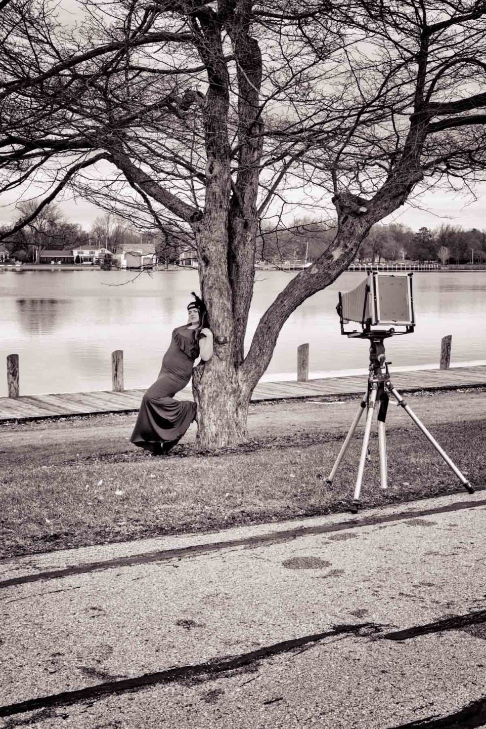 BTS woman model in red dress posing with large format camera
