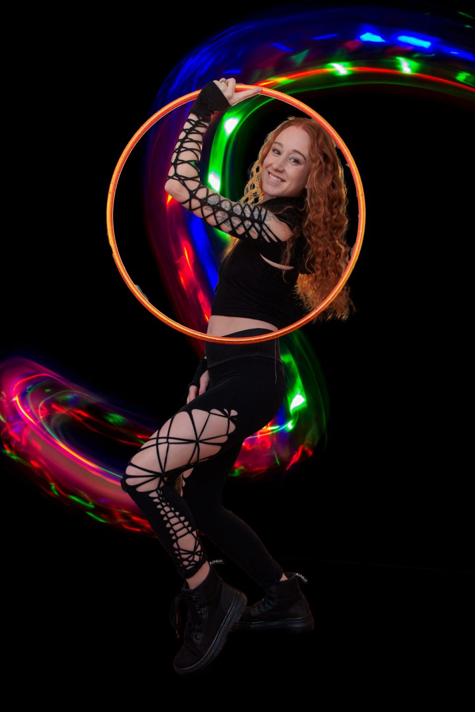 Hoop performer with rainbow lighting